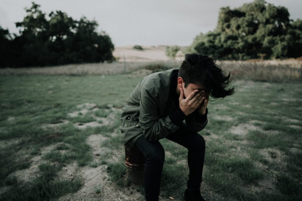 A young man holds his face in pain