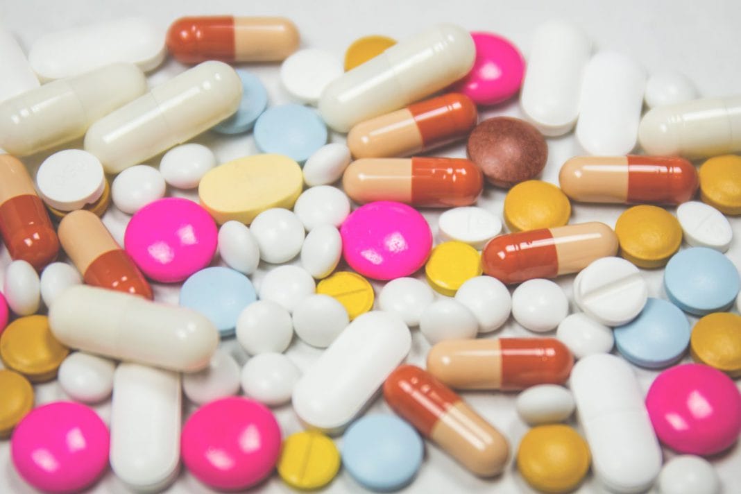 A selection of brightly coloured pills laid out on a surface