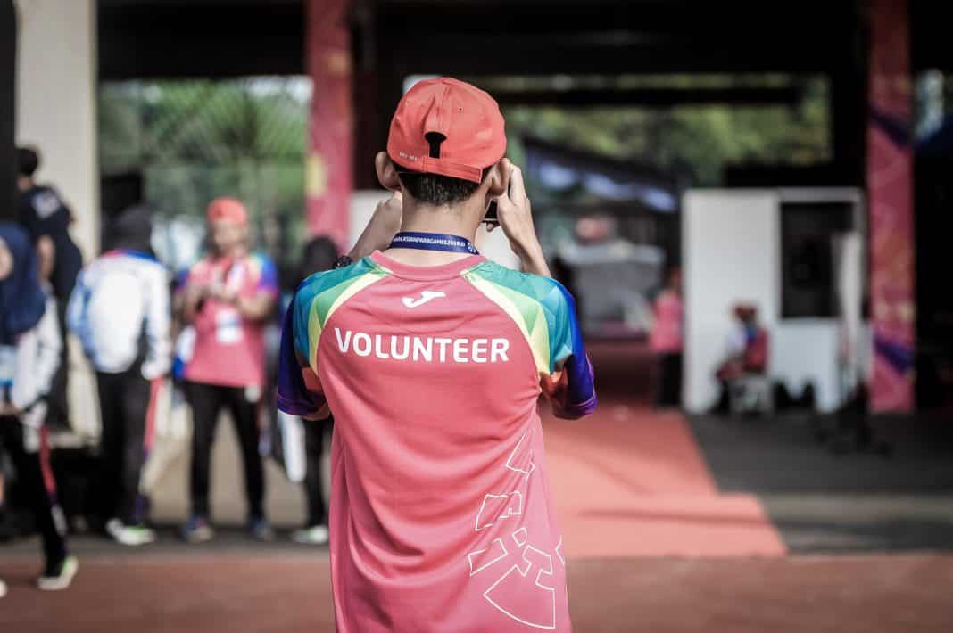 A man wears a red t-shirt saying 'volunteer'