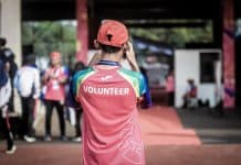 A man wears a red t-shirt saying 'volunteer'