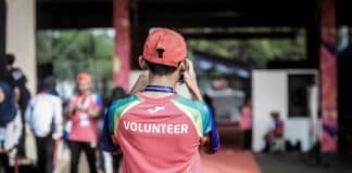 A man wears a red t-shirt saying 'volunteer'