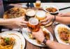 Friends toasting beer over a meal