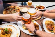 Friends toasting beer over a meal