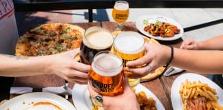 Friends toasting beer over a meal