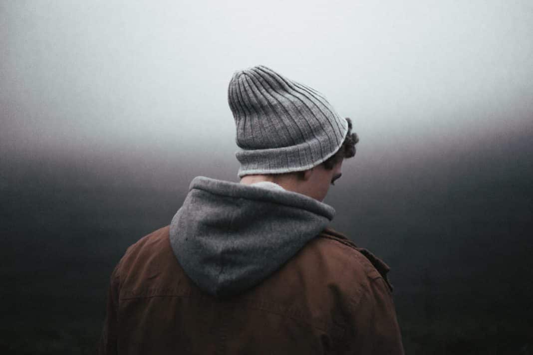 A man, turned away from the camera, looks sad