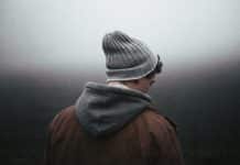 A man, turned away from the camera, looks sad