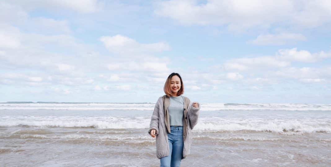 A woman stands smiling on Goolwa beach