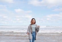 A woman stands smiling on Goolwa beach