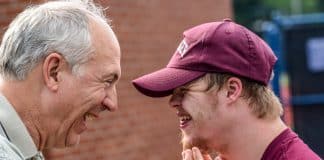 A young man with Downs Syndrome celebrates with his father