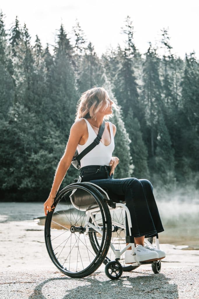 disabled woman riding wheelchair near trees