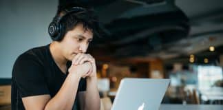 A young man looks at a computer screen.