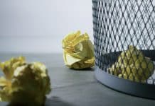 Yellow crumpled paper in a waste bin.