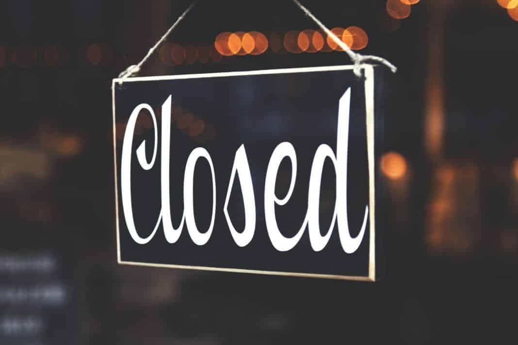 A black sign saying 'Closed' in curly handwriting.