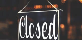 A black sign saying 'Closed' in curly handwriting.
