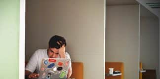 man wearing white top using MacBook