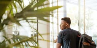 man holding glass door
