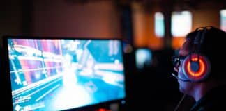 person using computer playing FPS game