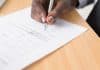 person writing on white paper