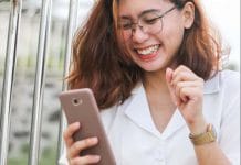 woman in white button up shirt holding silver iphone 6
