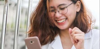 woman in white button up shirt holding silver iphone 6