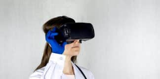woman in white coat holding blue and black vr goggles