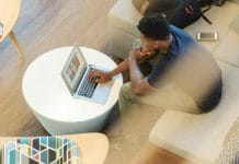 man sitting on couch using MacBook