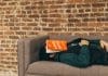 person sleeping on sofa near the wall