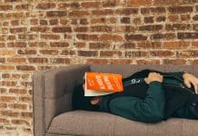 person sleeping on sofa near the wall
