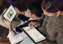 person in gray sweater holding Surface devices
