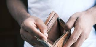 person holding brown leather bifold wallet