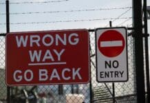 a red sign that says wrong way go back and no entry
