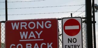 a red sign that says wrong way go back and no entry