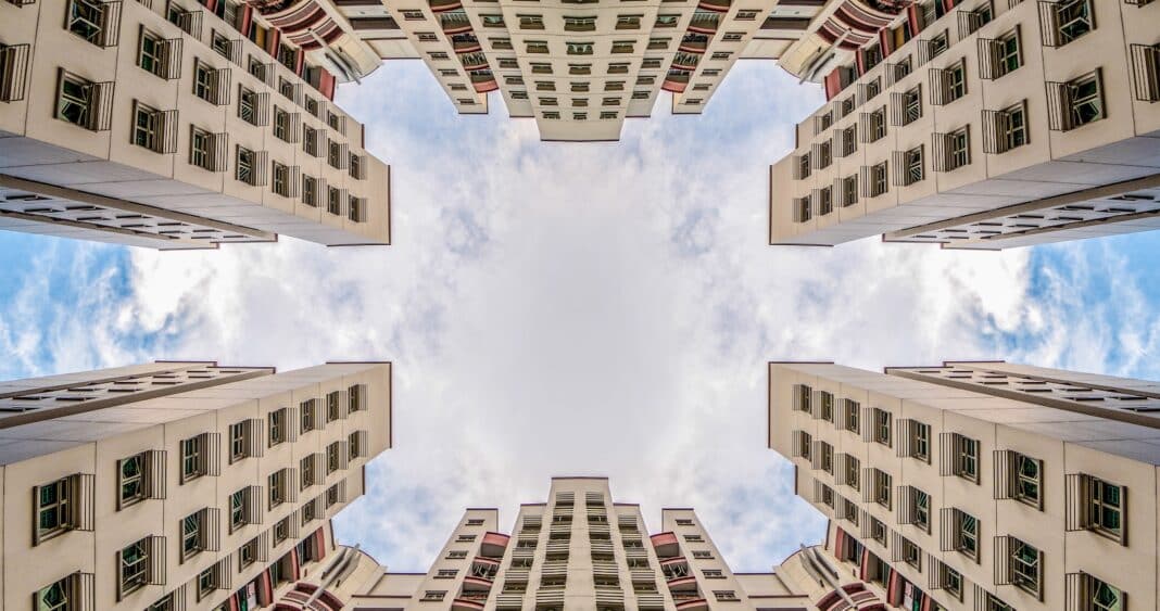 low angle photography of two white concrete buildings