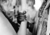 grayscale photo of man and woman holding their hands