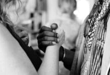 grayscale photo of man and woman holding their hands