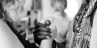 grayscale photo of man and woman holding their hands