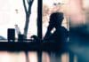 silhouette of a person sitting in front of a laptop