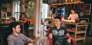 two men laughing white sitting on chairs