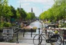 black city bike parked beside river during daytime
