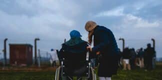 woman standing near person in wheelchair near green grass field