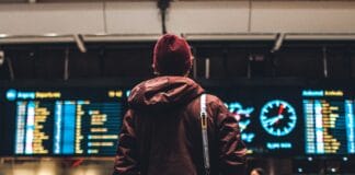 person looking up to the flight schedules