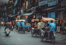 man driving white motor scooter on road