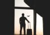 silhouette of man holding luggage inside airport