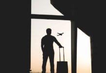 silhouette of man holding luggage inside airport