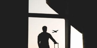 silhouette of man holding luggage inside airport