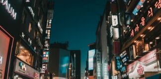 people walking between tall buildings