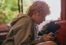 Portrait of a nonbinary autistic person using their mobile phone indoors