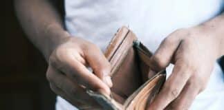 person holding brown leather bifold wallet