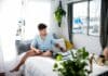 man sitting on bed near window