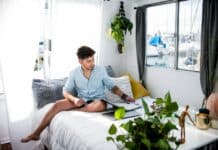 man sitting on bed near window